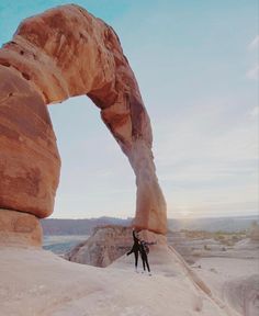 a person standing in front of a large rock formation