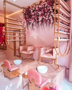 a room with pink furniture and flowers hanging from the ceiling