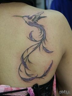 a woman's back with a bird tattoo on it