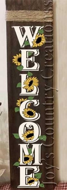 a wooden sign that says welcome home with sunflowers