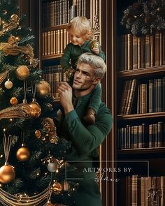 a man holding a small child in front of a christmas tree with bookshelves