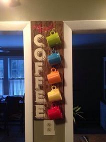 a wooden growth chart with coffee cups hanging on it