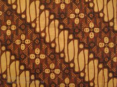 an intricately designed piece of cloth with brown and yellow designs on the fabric is shown