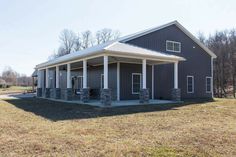 a large gray building sitting on top of a grass covered field