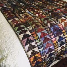 a bed with a colorful quilt on top of it