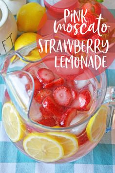 pink moscato strawberry lemonade in a glass pitcher with strawberries and lemons