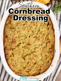 a casserole dish with cornbread dressing in it on a striped cloth next to bread and vegetables