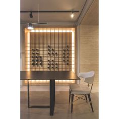 a dining room table with two chairs and a wine rack on the wall behind it