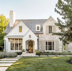 a large white house with stone steps leading to it's front door and windows