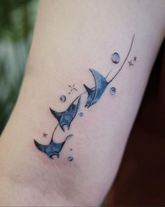 a tattoo on the leg of a woman with two stingfishs flying through the air