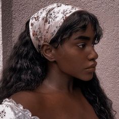 a woman with long hair wearing a white headband and looking off to the side