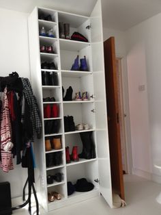 a white closet filled with lots of shoes and coats hanging on it's walls