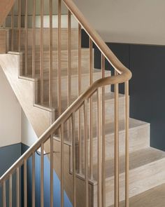 there is a wooden stair case next to the blue carpeted floor in this house