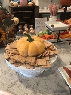 a table topped with lots of food on top of a white bowl filled with crackers