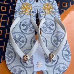 Nwt Tory Burch Pvc/Eva Flat Thong Flip Flop Flops Sandals New Ivory Mixed Logo Print With Gold Iconic Logo Tory Burch Flip-Flop So Lightweight And Comfortable You'll Want To Where Them Every Day Imported Made In Cambodia Brand New With Tags 100% Authentic As All Of My Items. I Have All Original Receipts From The Store. Sold Out Online And In Stores!!!!! Discontinued!!! Check My Other Listings The Quality Is Excellent!!!! Super Fast Shipping!!!!!! Chic White Flip Flops For Vacation, Casual Tan Flip Flops For The Beach, Adjustable White Flip Flops For Beach Season, Tory Burch Flip Flops, Iconic Logo, Tory Burch Shoes, Flip Flop, Flip Flop Sandals, Cambodia