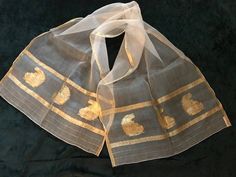 "In 1941, Sylvan Baar and Milton Beards opened a ladies scarf and accessories business on 37th Street in NYC. This beautiful example of their finest work is delicately made of 100% silk in a sheer look edged in a gold lame' border and an understated paisley design. It measures 46\" long x 17\" wide. This lovely piece of the past was worn on formal occasions with the finest of fur coats and is still perfect today for that elegant occasion when only a scarf of this vintage could make the outfit complete." Traditional Silk Scarves For Formal Occasions, Elegant Gold Silk Scarf For Festive Occasions, Elegant Gold Dupatta As Gift, Elegant Gold Dupatta, Vintage Brown Silk Scarf For Gift, Luxury Vintage Gold Scarf, Vintage Silk Shawl Scarf, Green Vintage Silk Shawl Scarf, Luxury Vintage Silk Scarf