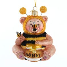 a glass ornament shaped like a bear holding a honey jar with the word honey on it