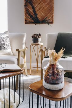 a living room filled with furniture and a painting hanging on the wall above it's coffee table