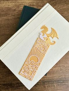 a card with an intricate design on the front, and a dragon in the middle