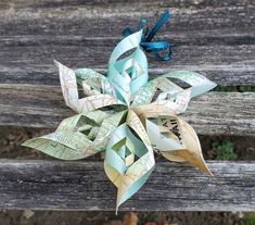 an origami flower sitting on top of a wooden bench