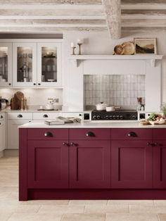 a kitchen with white cabinets and red counter tops