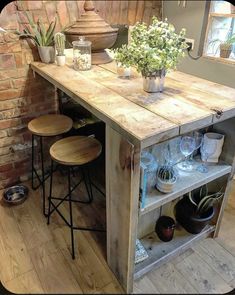 a kitchen island made out of an old pallet with stools and potted plants on top