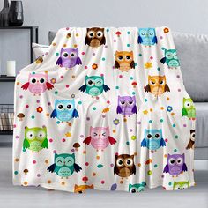 an owl themed blanket with polka dots and owls on it, sitting in front of a couch