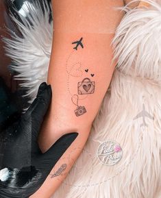 a woman's arm with a tattoo on it and an airplane in the sky