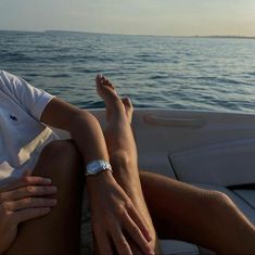 a person sitting on the back of a boat with their feet up in the air