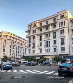 cars are parked on the street in front of an apartment building