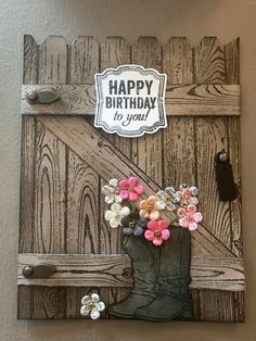 a birthday card with flowers in a cowboy boot on a wooden background that says happy birthday to you