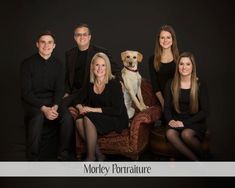 the family is posing for a photo with their dog in front of black backdrops