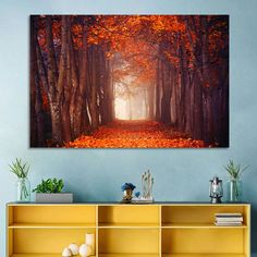 a painting on the wall of a forest with trees and leaves in fall colors is shown