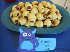 a plate full of pigs in a blanket on top of a blue table with a sign