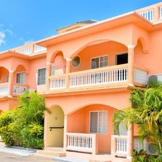 an orange building with white balconies and palm trees