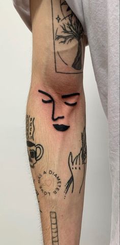 a man's arm with tattoos on it and his face drawn in black ink