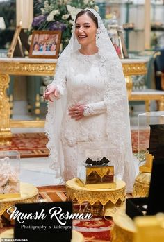 a woman in a wedding dress standing next to a table with gold and white decorations