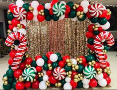 a christmas balloon arch decorated with candy canes and gold, green and red balloons