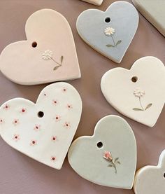 several ceramic heart shaped tags with flowers on them