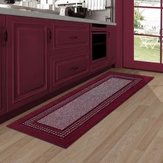 a kitchen with red cabinets and white counter tops is pictured in this image, there is a rug on the floor