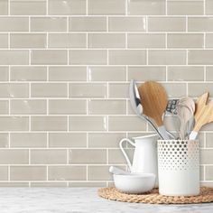 kitchen utensils and wooden spoons are on the counter