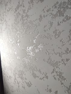 the wall is covered in white paint and has small spots on it's surface