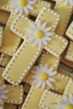 decorated cookies with daisies and pearls are arranged in the shape of crosses on top of each other