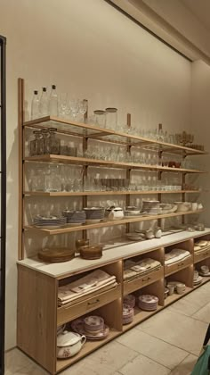 the shelves are filled with glassware and plates