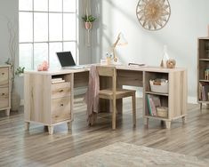 a wooden desk with a laptop on top of it next to a book shelf and window