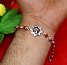 This amazing silver Rakhi crafted from 925 silver with immense precision. It exudes excellent craftsmanship and will surely look wonderful on your brother's wrist. handmade custom design Aum or OM Bracelet Or Rakhi bracelet this is special design beaded bracelet we can use either Rakhi bracelet or daily use bracelet for unisex. Best Rakshabandhan wishes sibling gift for your brother and sister's , buyer can be select bracelet style from option we have Rudraksh, black basil rosary, white rosary a Rudraksh Rakhi Design, Symbolic Sterling Silver Bracelets For Festivals, Adjustable Silver Bracelets For Puja, Sterling Silver Bracelets For Festivals, Fusion Style Sterling Silver Beaded Bracelets As Gift, Handmade Sterling Silver Bracelet For Festivals, Sterling Silver Fusion Beaded Bracelets As Gift, Sterling Silver Bracelets With Silver Beads For Festive Occasions, Sterling Silver Fusion Beaded Bracelets For Gifts