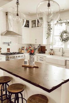 a kitchen with three stools and an island in front of the stove top oven