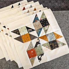 six blocks of quilted fabric laid out on the floor, each with different shapes and sizes