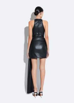 Stretch faux leather high waisted mini skirt with a long side drape, ruched waist, and hidden zipper at side seam. True to size. Material: 48% Polyurethane, 48% Polyester, 5% Spandex Care: Professional Dry Clean Only High Waisted Mini Skirt, Faux Leather Mini Skirt, Leather Mini Skirt, Feather Dress, Runway Collection, Leather Mini Skirts, Leather Mini, White Ink, Bridal Collection