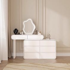 a white dresser sitting next to a mirror on top of a wooden floor in a room